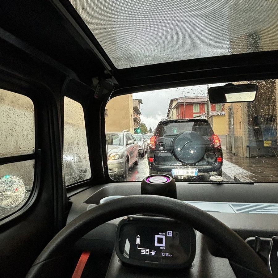 Interno di una Citroën Ami durante la guida sotto la pioggia